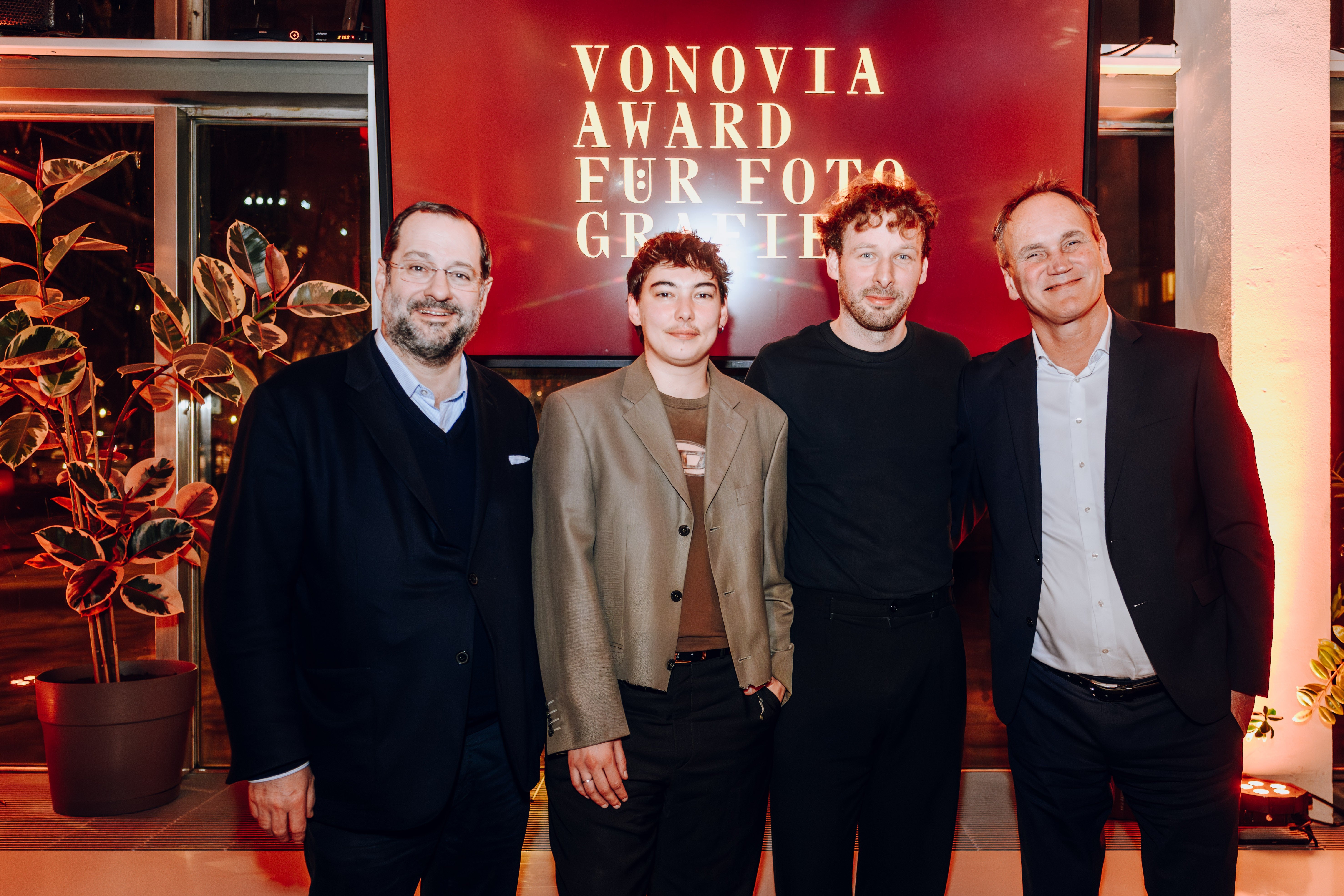 Vier Personen posieren bei einer Preisverleihung. Hintergrund Schrift: Vonovia Award für Fotografie.